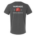 A dark gray short-sleeve t-shirt shown from the back, featuring a white graphic print that reads 'YARDAGE.' and 'SANTA CRUZ-CA' with '19' and '97' surrounding a red flag design with a white 'Y'.
